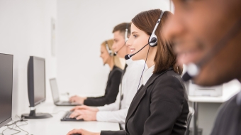 Group of agents sitting in line in a bright call centre.