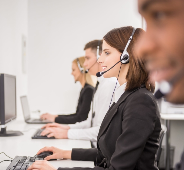 Group of agents sitting in line in a bright call centre.